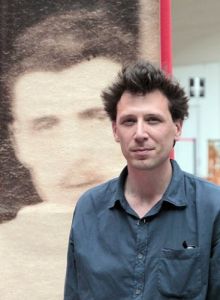 French bookseller Alban Causse poses in front of a blown-up print of a previously unseen photo of French poet Rimbaud at the Paris Old Books fair in the Grand Palais. Causse and his colleague Jacques Desse found the photo at a flea market. French bookseller Alban Causse poses in front of a blown-up print of a previously unseen photo of French poet Rimbaud at the Paris Old Books fair in the Grand Palais. Causse and his colleague Jacques Desse found the photo at a flea market.